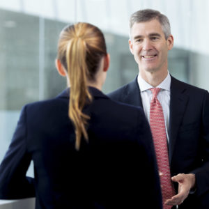 Businessportrait eines Geschäftsführers im Gespräch mit einer Kollegin